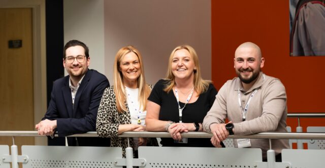 a team shot of 4 people smiling at the camera