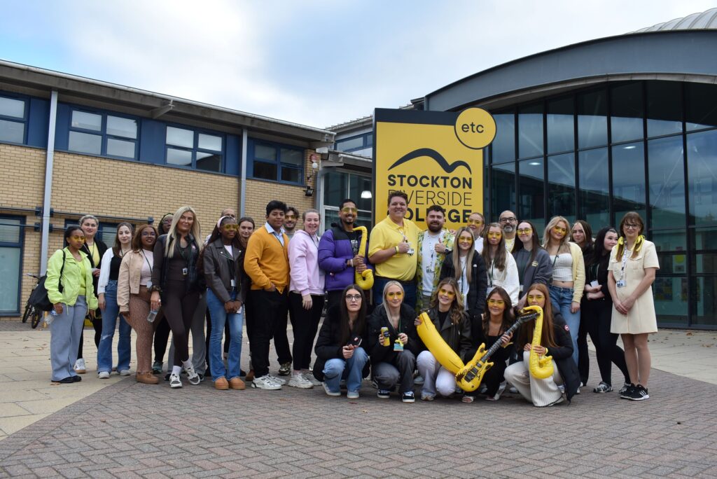Health and Social Care students stood in front of the college sign.