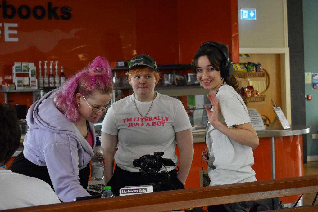 Film and TV students with artist in library for filming the project