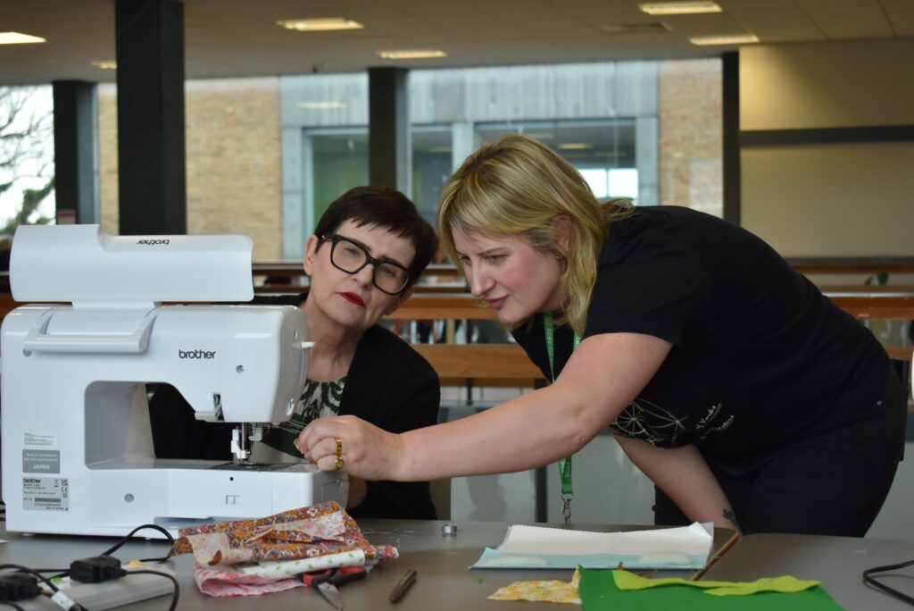 Volunteers using a sewing machine