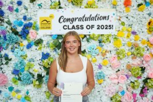 Student standing in front of flower wall at Stockton Riverside College
