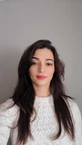 a person with a white jumper and long dark hair takes a selfie