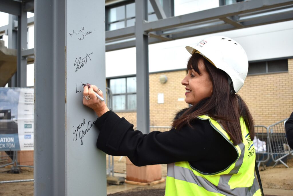 Louise Davies signing the steel at new NETA facility