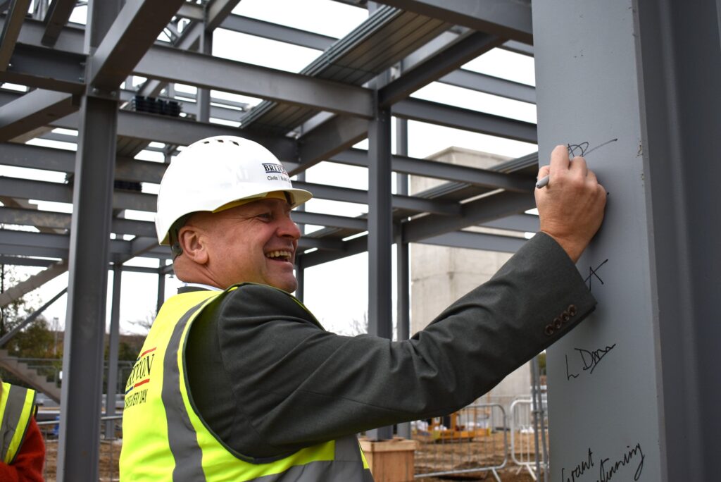 Sean Johnston signing the steel at new NETA facility