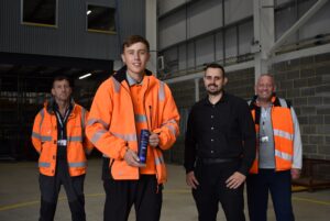 Award winning JMAC apprentice Rhys with his trophy, his boss Ryan and instructors from NETA Training