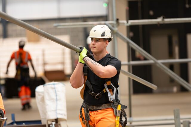 a scaffolder carrying a pole