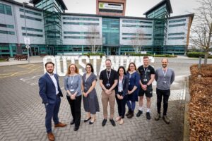 Members of Bede staff outside Bede Sixth Form with Outstanding letters