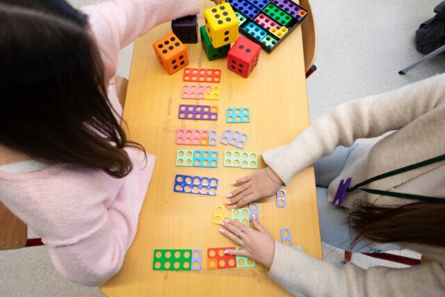 a view from over a table with school dominoes. faces are not visible