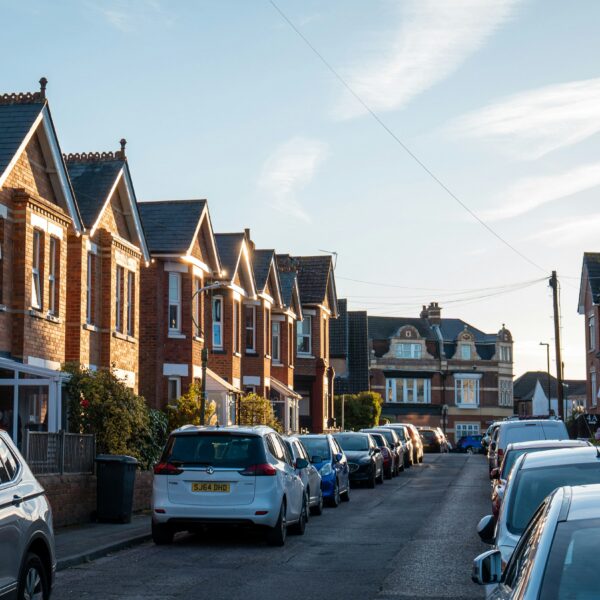 an image of a row of houses with cars infront on the road