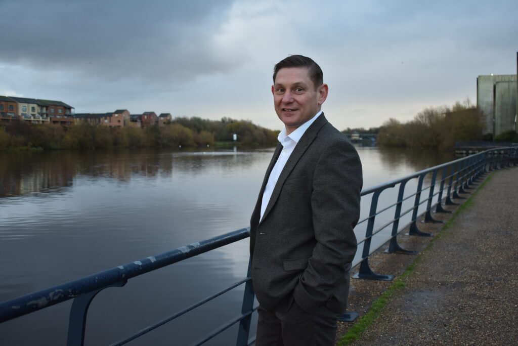 Deputy chief executive of Education Training Collective standing beside the river.